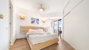 A modern bedroom with a wooden bed, white linens, and a ceiling light fixture. - M11 Antares - Apartment (Sitio de Calahonda)