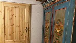 Een houten deur en een blauwe kast met bloemmotieven.