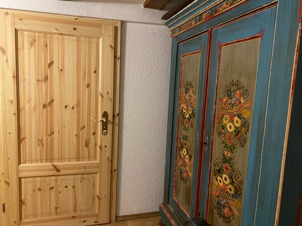 Une porte en bois et un meuble bleu orné de motifs floraux.