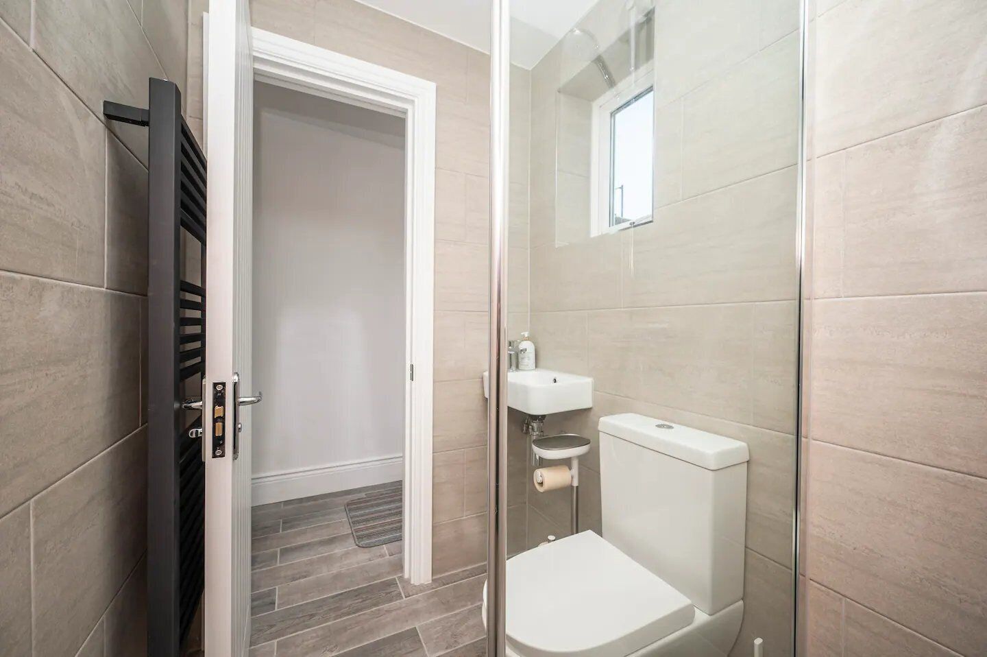 A modern bathroom with a shower, toilet, and sink.