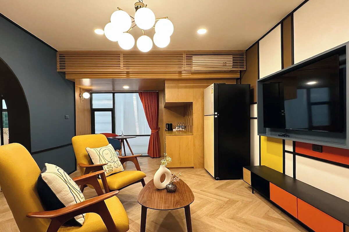 A modern living room with a sofa, a coffee table, and a TV.