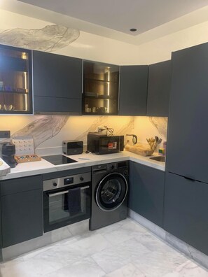 Enjoy cooking in this well-equipped kitchen with a dishwasher, compact oven, and front-loading washing machine.