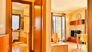 Un salon moderne avec un plancher en bois, un téléviseur, une horloge et un coin repas.