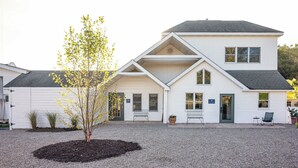 A two-story building with a symmetrical facade, a central entrance, and a gravel driveway. - Hemlock Neversink  (Neversink)