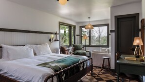 A neatly arranged bedroom with a large bed, a desk, and a chair. There are windows providing natural light and a view of the outdoors. - Hemlock Neversink  (Neversink)