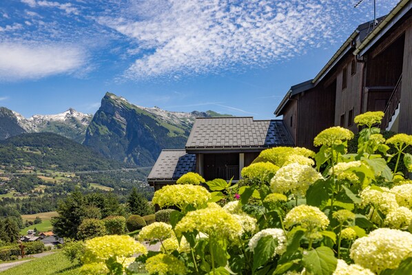A mountain landscape with a house and a clear sky.