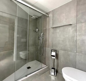 Een douche, handdoeken, zeep, shampoo