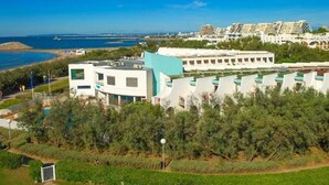 A coastal hotel with modern architecture, a pool, and a view of the sea. - Studio with Sea View Terrace on the Beach in La Grande Motte – Renovated 2026 (La Grande-Motte)