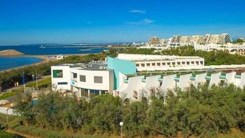 Un hotel costero de arquitectura moderna, con piscina y vistas al mar.