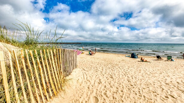 A sandy beach with a wooden fence, beach chairs, and umbrellas. - Studio with Terrace on the Beach in La Grande Motte – Renovated 2026 (La Grande-Motte)