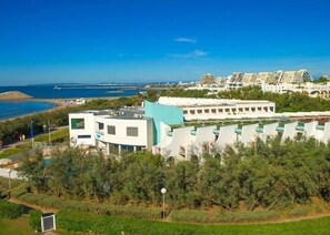 A coastal hotel with modern architecture, a pool, and a view of the sea. - Studio with Terrace on the Beach in La Grande Motte – Renovated 2026 (La Grande-Motte)