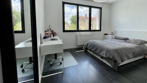 A modern bedroom with a large bed, a desk, and a window. - Magnificent contemporary architect-designed villa  (Mérignac)