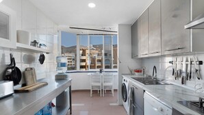 A modern kitchen with a large window, a washing machine, and a sink. - ‘Graciosa’ Holiday Apartment with Sea Views, Private Terrace & Wi-Fi (Arona)