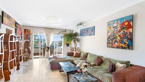 A living room with a sofa, coffee table, and artwork on the walls. - ‘Graciosa’ Holiday Apartment with Sea Views, Private Terrace & Wi-Fi (Arona)