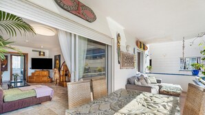 A spacious living area with a large glass table, comfortable seating, and a television. - ‘Graciosa’ Holiday Apartment with Sea Views, Private Terrace & Wi-Fi (Arona)