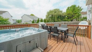 Una terraza con un jacuzzi, una mesa y sillas.