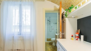 Une salle de bain équipée d’une douche, de toilettes et d’un lave-linge.
