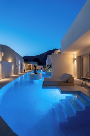 Ein moderner Poolbereich mit wellenförmigem Design, einer Liege und einer kleinen Sukkulente.