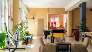 A lobby with seating, a pool table, and a vending machine. - Meet Hostel Cervia (Cervia)