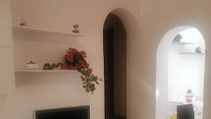 Een moderne woonkamer met een flatscreen televisie, een eettafel en een trap naar een andere kamer.