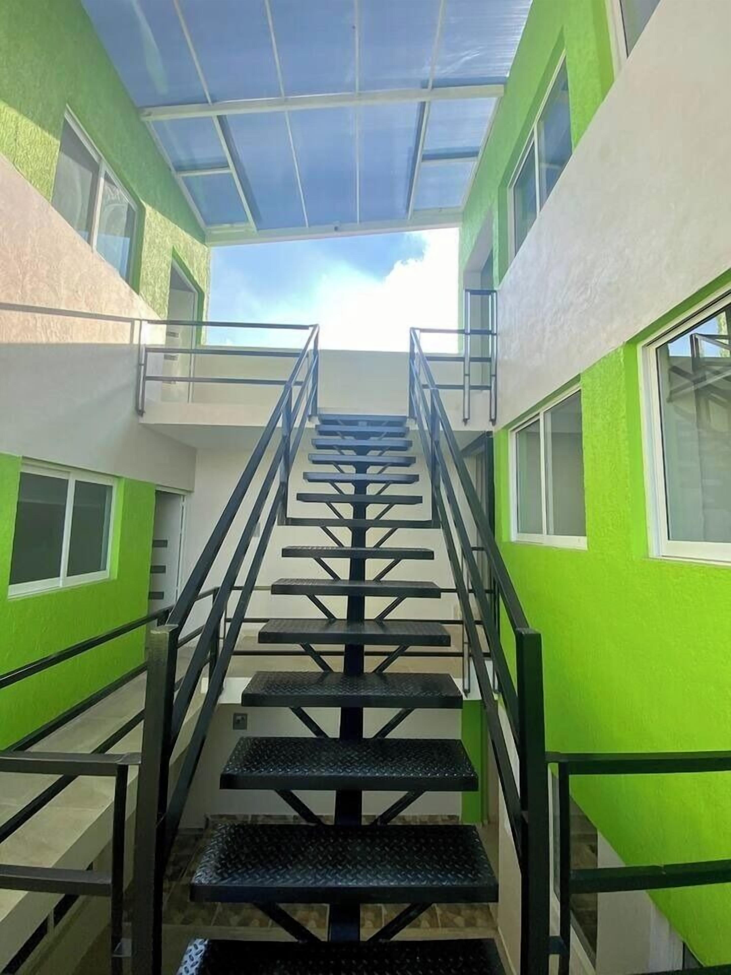 A staircase with glass railings leading to a skylight.