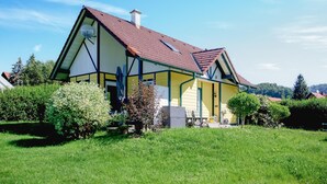 A two-story house with a steeply pitched roof, a chimney, and a satellite dish. - Ferienhaus in Foetschach (Leutschach an der Weins)