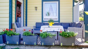 An outdoor seating area with a table and chairs, surrounded by planters with flowers. - Ferienhaus in Foetschach (Leutschach an der Weins)