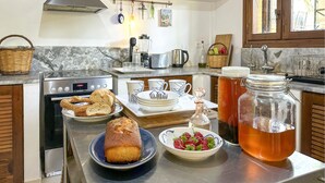 Una cocina con estufa de acero inoxidable, cafetera y diversos utensilios.