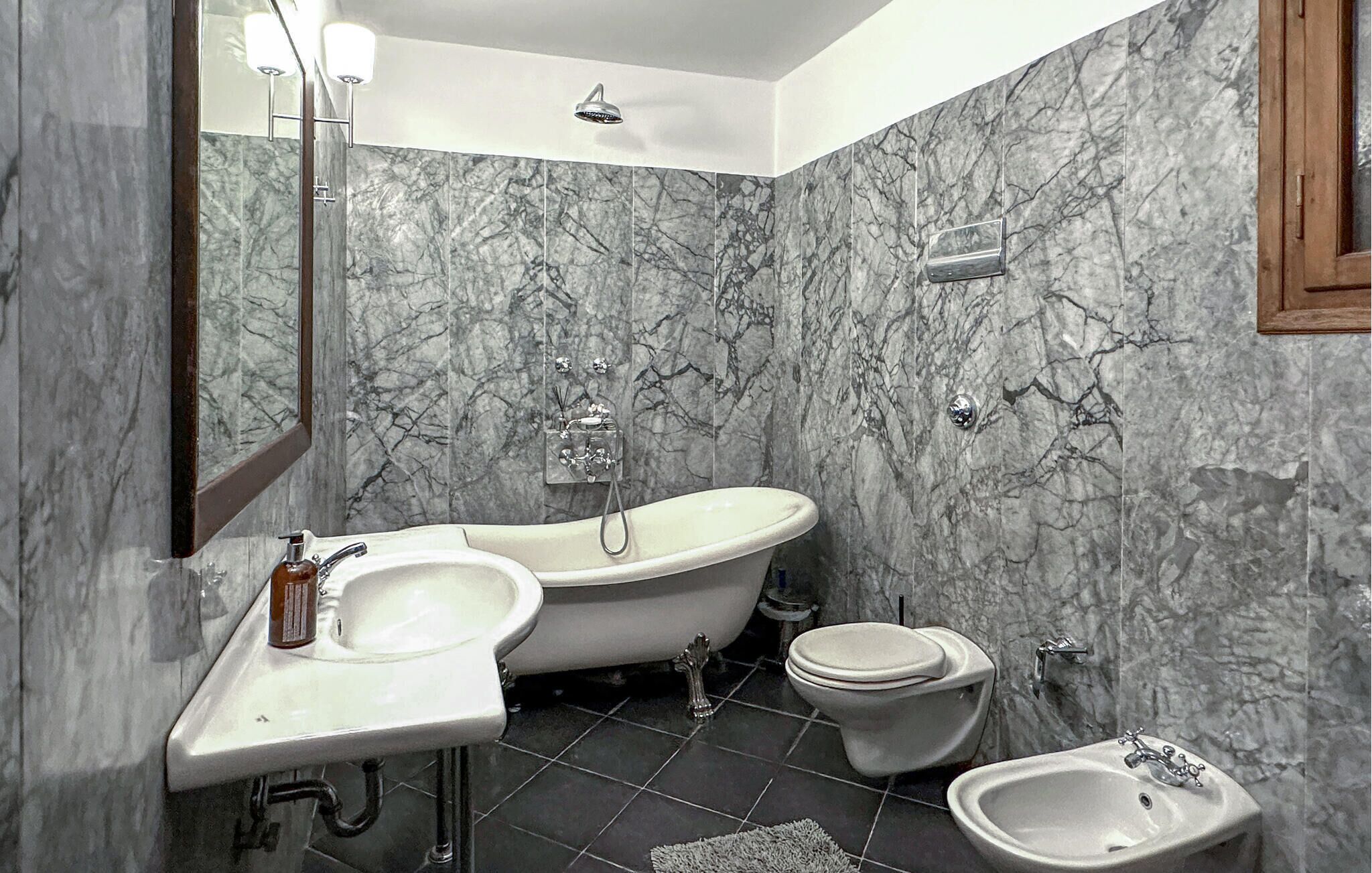 Une salle de bain comprenant une baignoire sur pieds, un lavabo, des toilettes et un bidet.