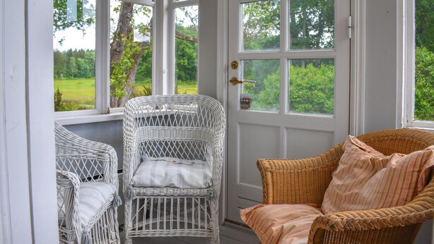 A room with two wicker chairs and a view of a green landscape through large windows. - Cozy home in Mörrum with WiFi (Mörrum)