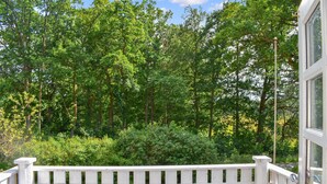 A balcony with a white railing overlooking a dense forest. - Cozy home in Mörrum with WiFi (Mörrum)