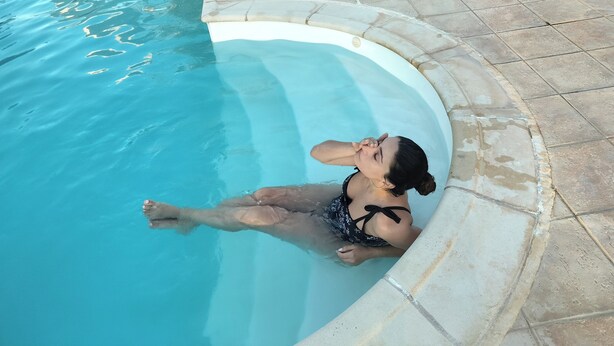 A person relaxing in a swimming pool with a tiled deck surrounding it. - Όμορφο εξοχικό στούντιο με πισίνα & κήπο,εύκολη πρόσβαση, 6χλμ από αεροδρόμιο (Kokkini Hani)