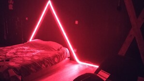 Una habitació amb poca llum, un llit i un seient de bossa de febrades.