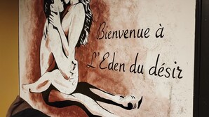 Paret amb un quadre de dues persones abraçant i el text "Bienvenue à L'Eden du désir".