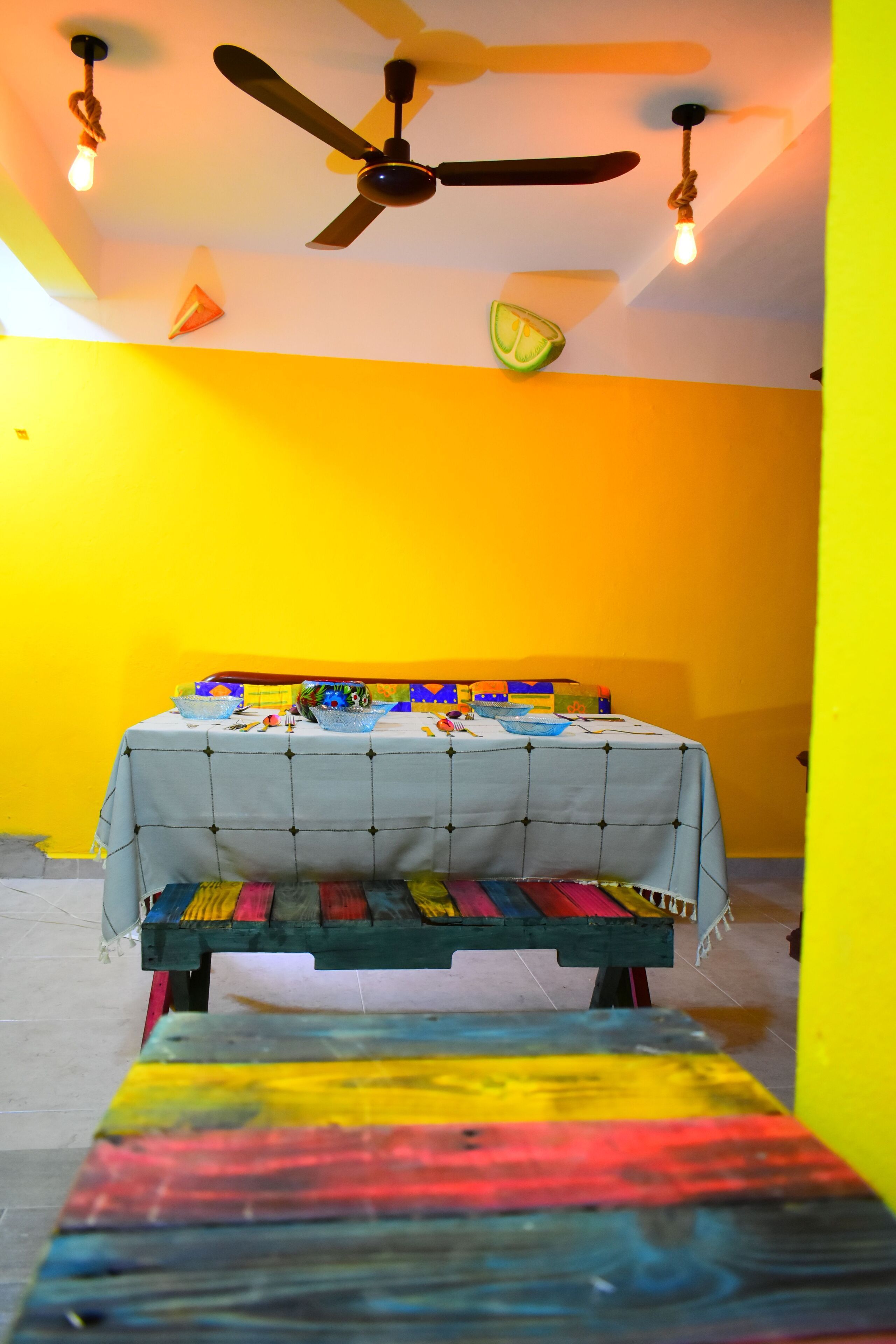 Quarto com cama, ventilador de teto e luminária.