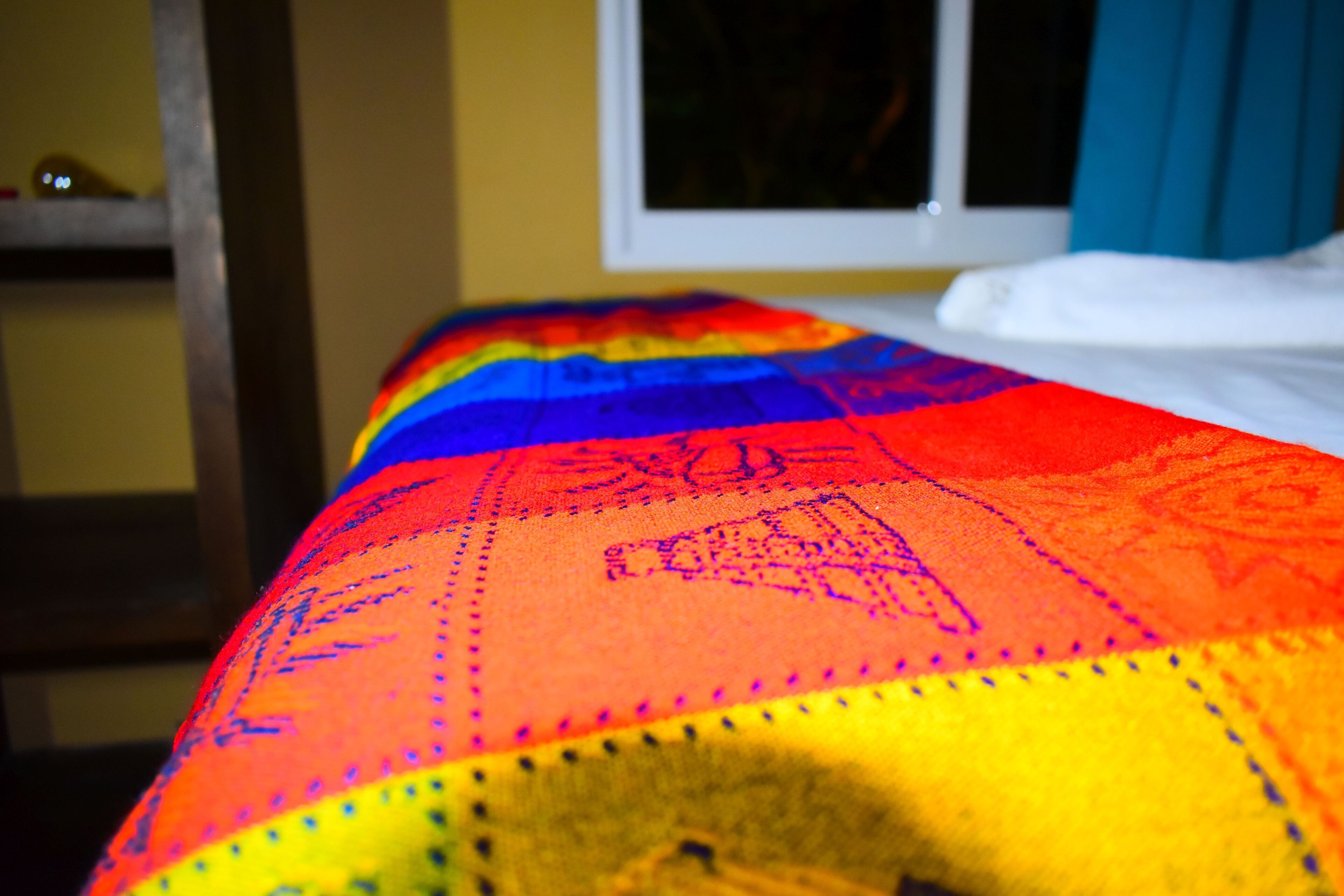 Un lit recouvert d’une couverture aux couleurs vives.