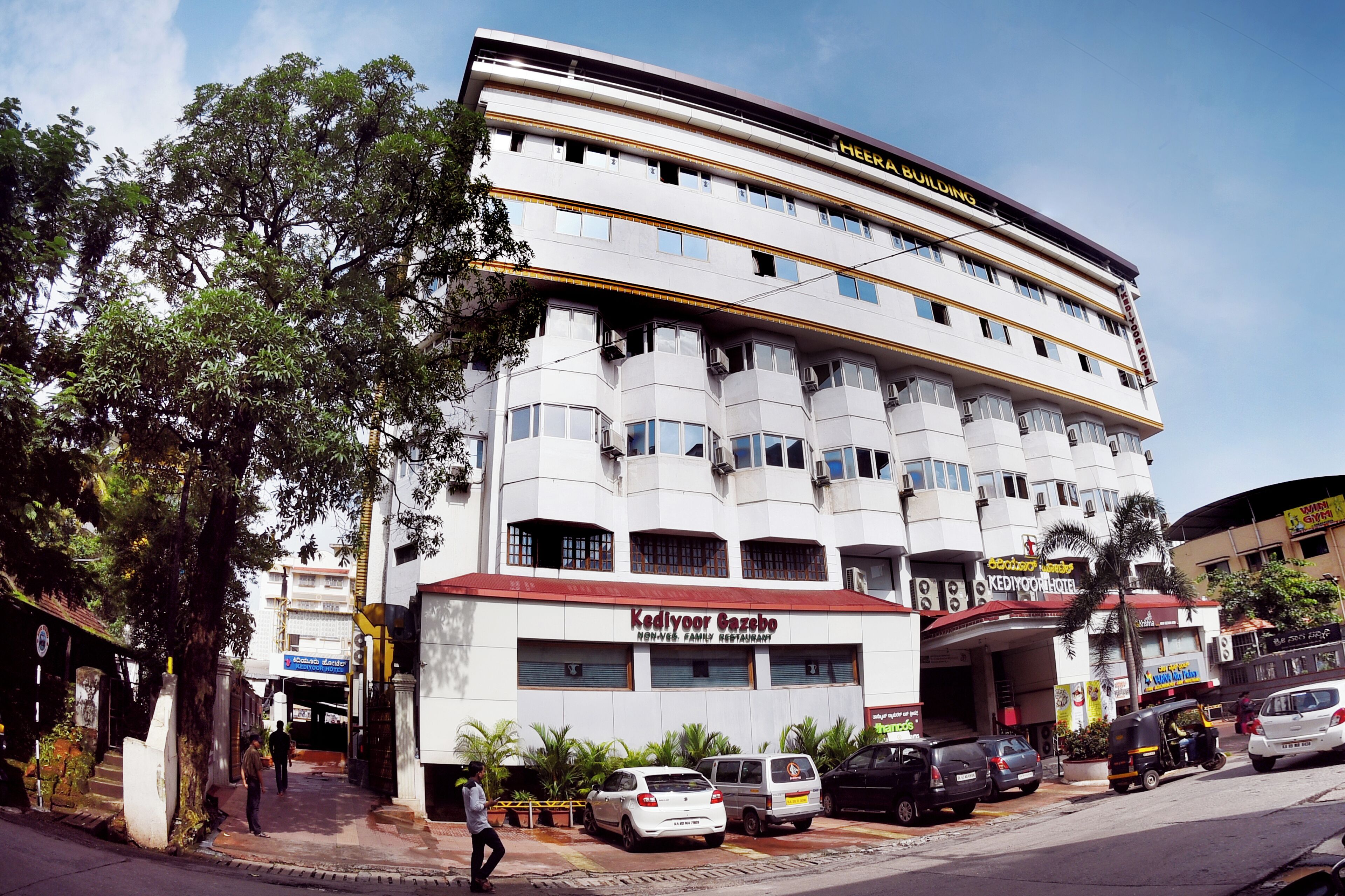 A multi-story hotel with a prominent sign for 'Kediyoor Gazebo' and 'Heera Building'.