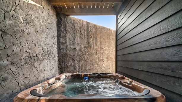 A hot tub with water, set against a textured wall and wooden siding. - Free Dollywood Tix/10Min2Dollywood/DogsOK (Sevierville)