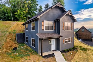 A two-story house with a front porch, a garage, and a small driveway. - Free Dollywood Tix/10Min2Dollywood/DogsOK (Sevierville)