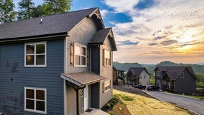 A residential building with a grey exterior, a front porch, and a driveway leading to parked cars. - Free Dollywood Tix/10Min2Dollywood/DogsOK (Sevierville)