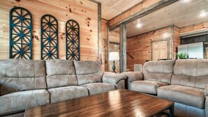 A cozy living room with a wooden ceiling, a large sofa, and a wooden coffee table. - Free Dollywood Tix/10Min2Dollywood/DogsOK (Sevierville)