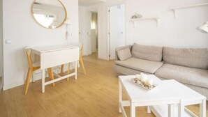 Ein modernes Wohnzimmer mit einem weißen Schreibtisch, einem beigen Sofa und einem weißen Couchtisch.