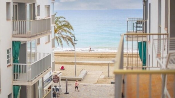 Blick vom Balkon auf einen Strand bei klarem Himmel.