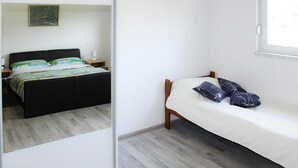 Ein Schlafzimmer mit einem Bett, einem Nachttisch, einem Schminktisch und einem Fenster.