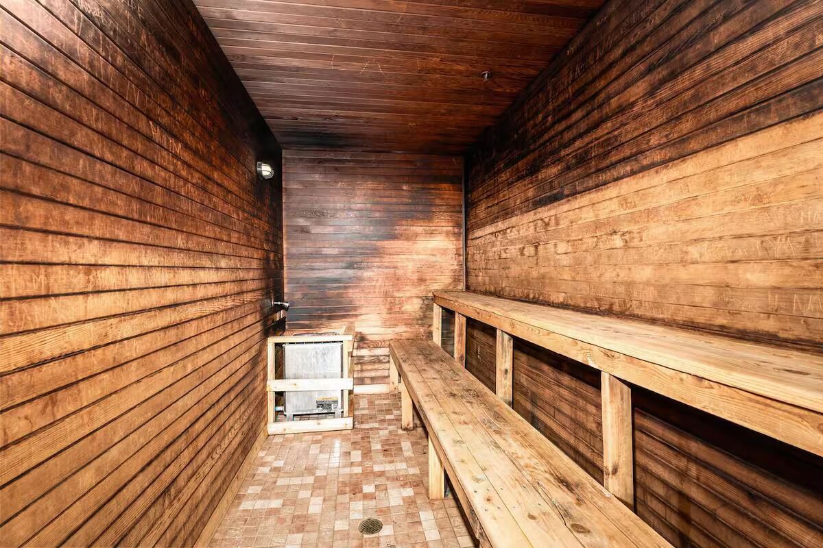 A sauna room with wooden walls and benches.