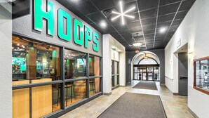 A hallway with a 'HOOPS' store on the left, featuring large windows and a wooden barrel.