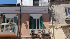 A building with a wooden door, a balcony, and outdoor seating. - DeA ApartRooms (Termoli)