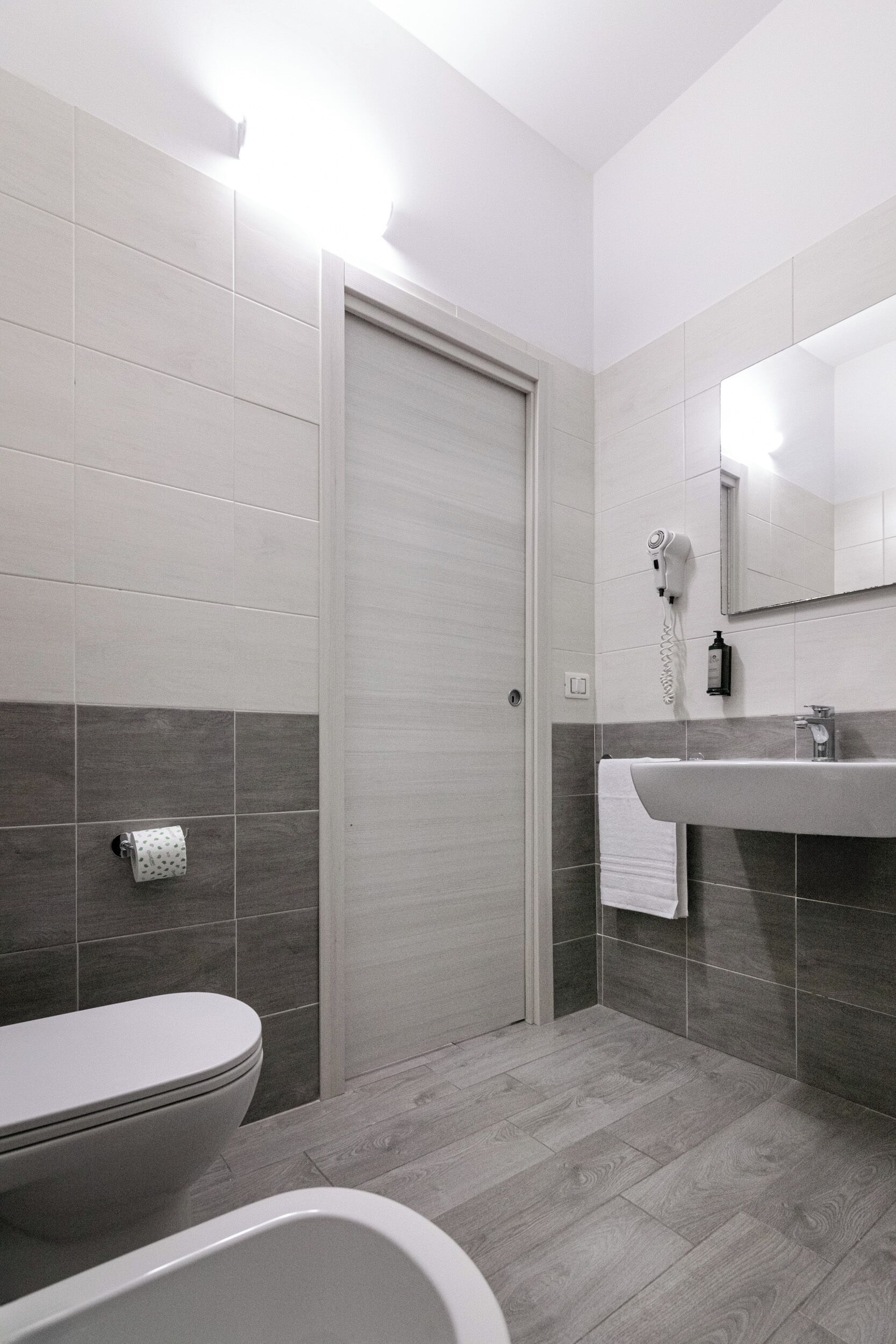 A modern bathroom with a toilet, sink, and bathtub.
