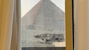 A view of the Great Pyramid of Giza through a window with curtains. - White House Pyramids View (Giza)