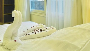 A hotel room with a bed, a window with curtains, and a view of a pyramid. - White House Pyramids View (Giza)